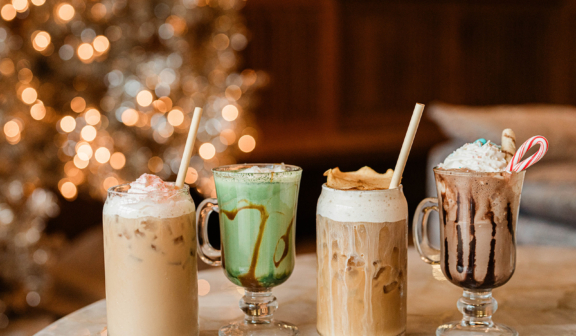 holiday coffee drinks lined up infant of a lit tree