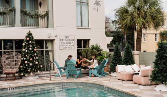 group cheering around a firepit next to the pool