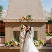 wedding couple kissing in front of outdoor fireplace