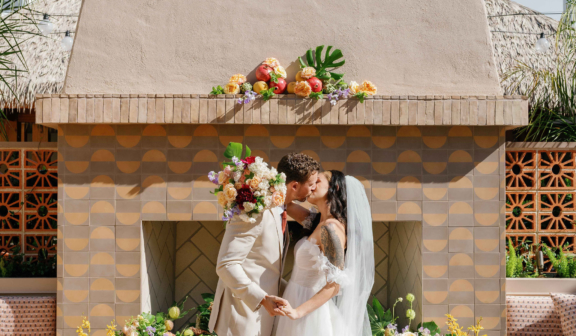 wedding couple kissing in front of outdoor fireplace