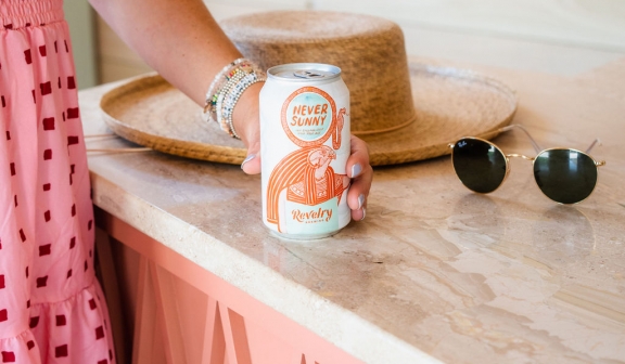 A woman placing a soda can on top of a cabinet