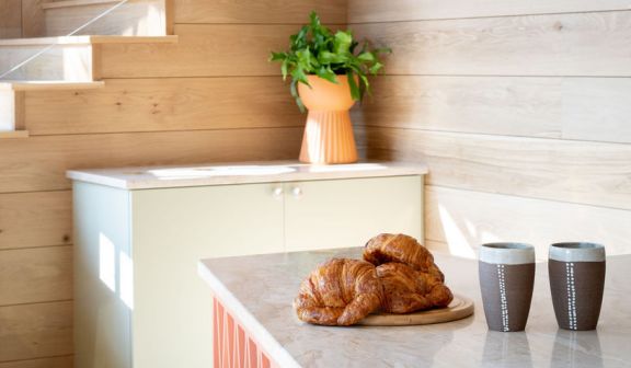 A plate of croissants next to coffee cups placed on a table