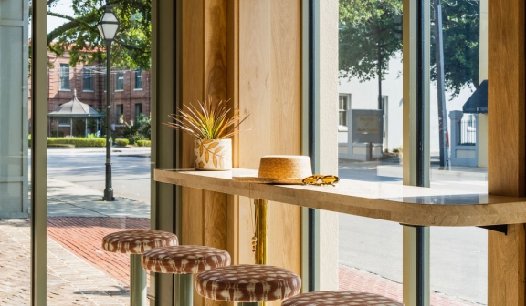 A hat placed on a window-side table at the Little Palm Bar.