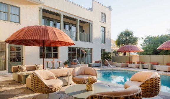 Patio chairs and table next to the outdoor pool at Ryder Hotel.
