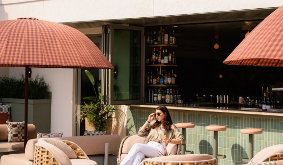 A woman sitting on the patio chair near the pool