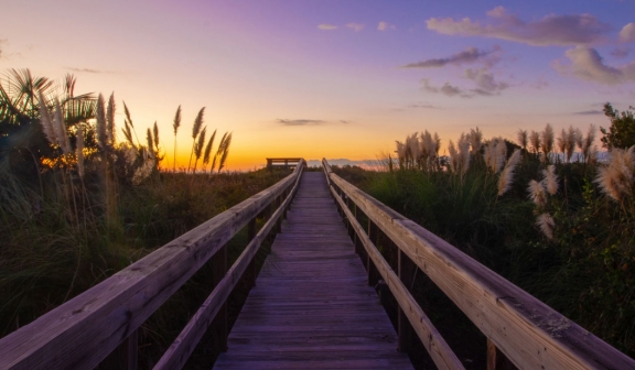 Beach boardwalk with a beautiful sunset in the background
