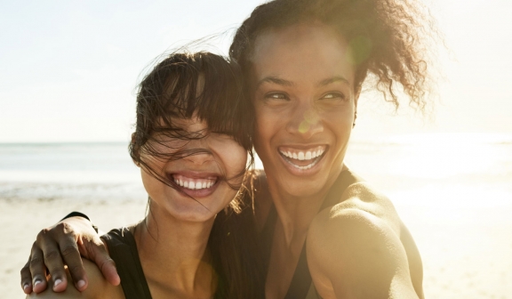 Two women on the beach laughing