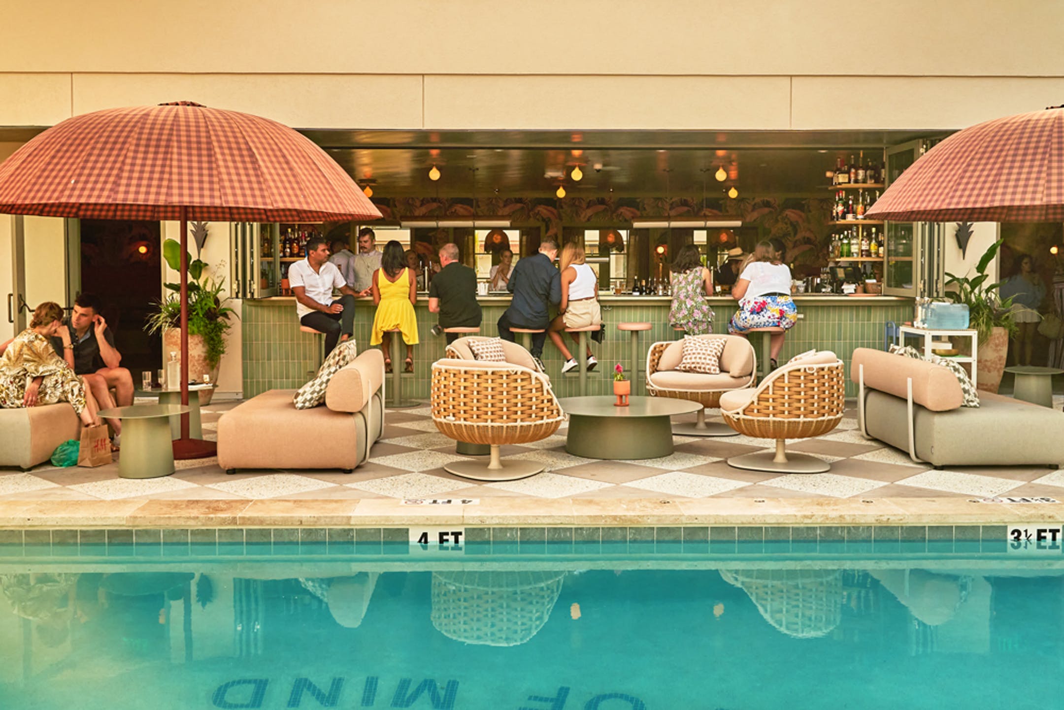 People mixing & mingling at outdoor bar and pool