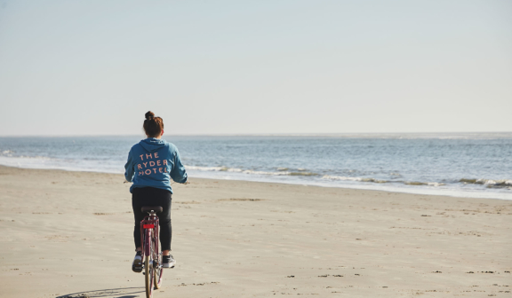 A woman riding a bike on the beach