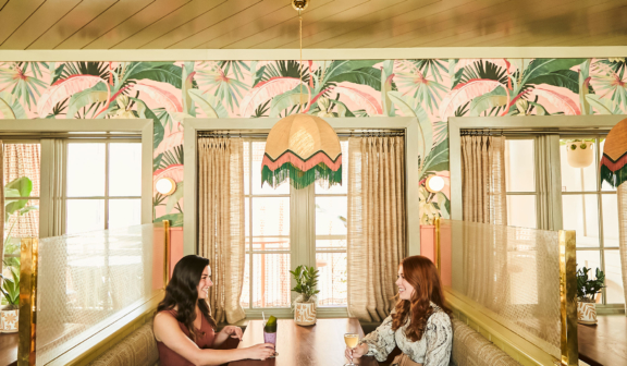 The friends having cocktails in a restaurant booth