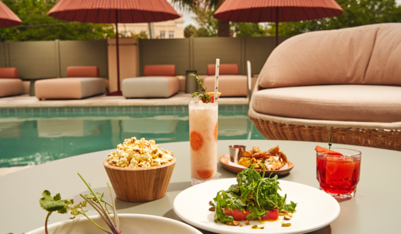 poolside table with cocktails and food