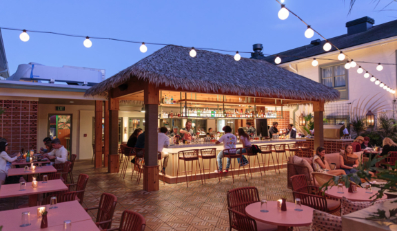 people sitting at outdoor patio bar at night