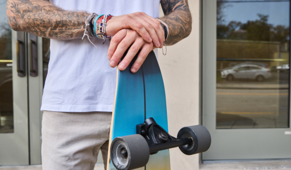 man holding up longboard