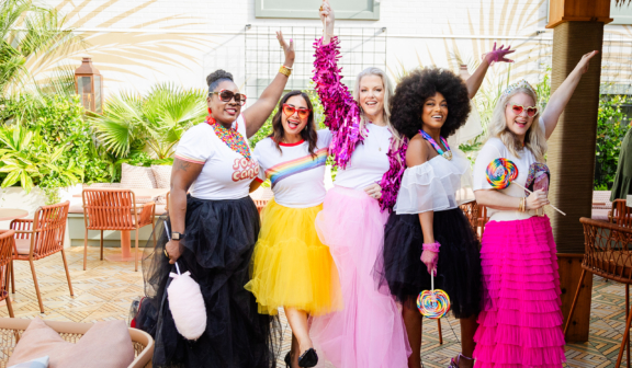 five women in vibrant clothes having a good time