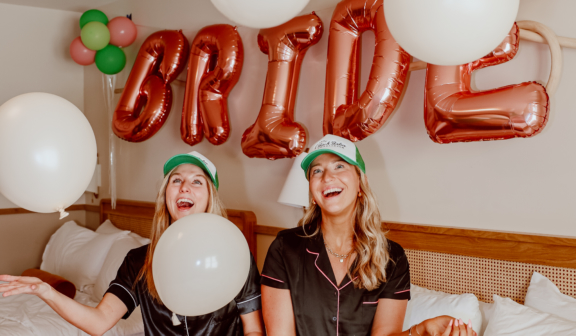 two women in pajamas celebrating a bride in a hotel room