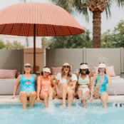 five women with legs in the water poolside