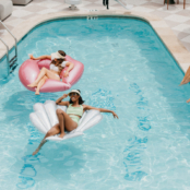 women hanging out in pool on floats with cocktails