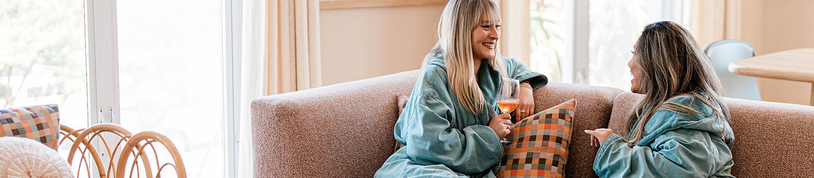 two girls on sofa in palm suite in robes