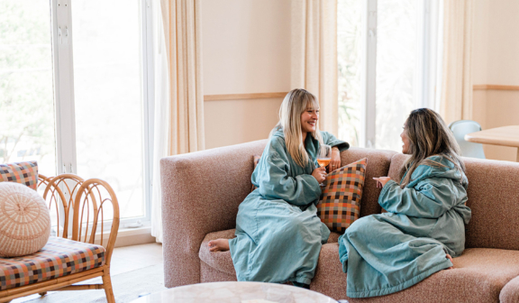 two girls on sofa in palm suite in robes