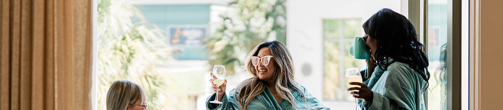 three girls standing on balcony in green robes